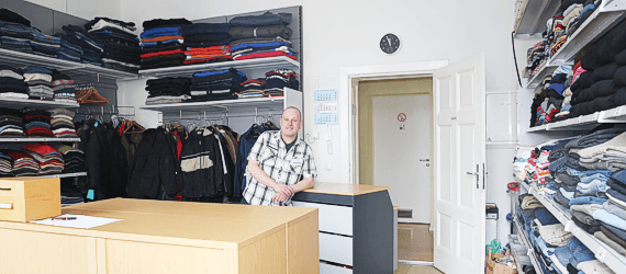 Kleiderkammer mit Kleiderstangen und gespendeter Kleidung